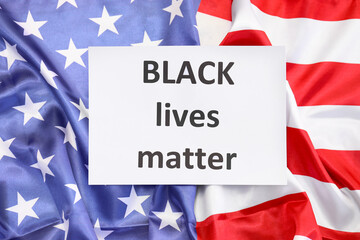 Paper with text BLACK LIVES MATTER and flag of USA, top view