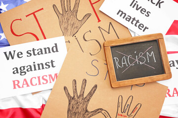 Chalkboard with crossed out word RACISM and placards