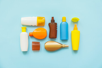 Bottles of sunscreen on color background