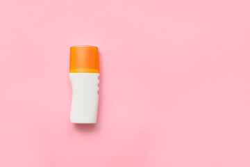 Bottle of sunscreen on color background