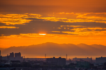 夕焼けの中、雲に隠れる太陽