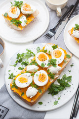 Toasted bread with pumpkin puree, cream cheese, green onion, herbs and boiled eggs for healthy lunch or breakfast.