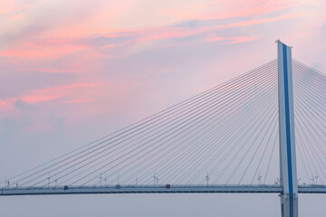 Fototapeta na wymiar A bridge crosses the sea at sunrise and sunset in hainan, China.