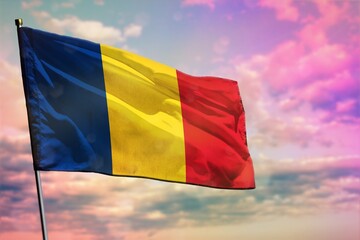 Fluttering Romania flag on colorful cloudy sky background. Prosperity concept.