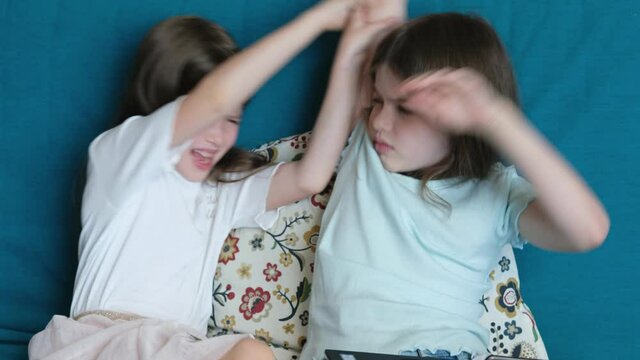 children sit on the couch with a laptop and fight, children quarrel, sisters swear