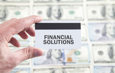 Male hand showing Financial Solutions text on credit card.