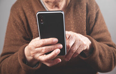 Caucasian elderly woman using smartphone.