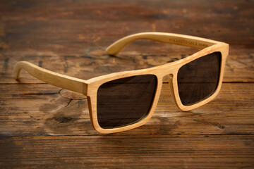 Bright wooden sunglasses on wooden surface
