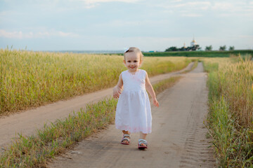 The little girl is making his way through the grass