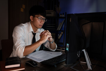 Fototapeta na wymiar Asian businessman concentrated working until late overtime in office at night