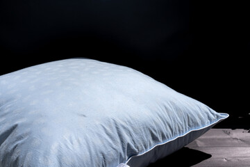 A pillow on a black background is dried in the sun