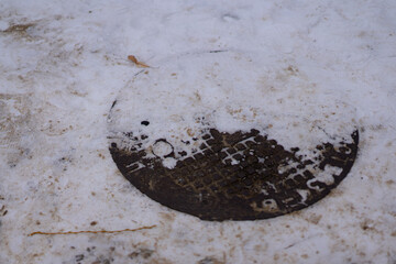 Closed manhole in the snow in winter