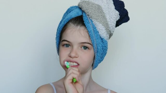 little girl brushes her teeth, portrait on a white background