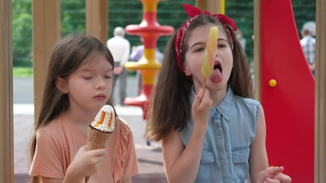 little children eat ice cream in the playground