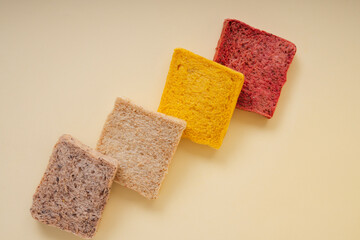 Colourful sliced of bread over yellow background.