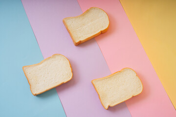 Home made organic sliced bread over rainbow colourful background.