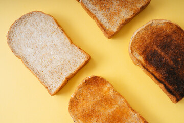Grill burnt home made organic sliced bread over yellow background.
