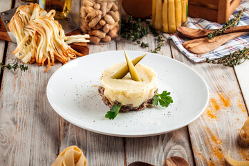 Mashed potato with beef in creamy sauce pickles