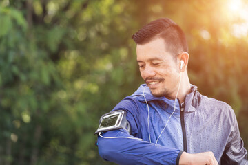 Obraz premium A man in sport hoodie jogging in the city park in the evening after stressful work. Runner jogging training and workout exercising power walking outdoors in forest city. Stock photo