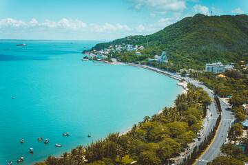 Panoramic coastal Vung Tau view from above, with waves, coastline, streets, coconut trees and Tao Phung mountain