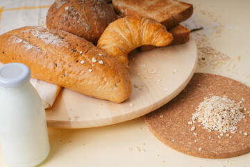 Group of many type of bread on a plate and a bottle of milk. Top view.