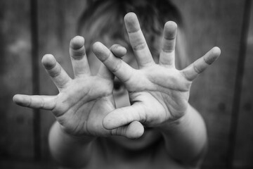 The child put his hands forward defensively and looks at the reaction