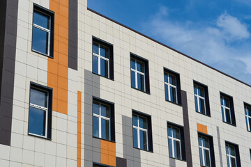 facade of a modern building on a bright Sunny day, siding and Windows, beautiful exterior of the new building