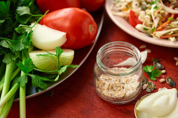 healthy food - fresh chopped vegetables on a wooden background, tomatoes and greens