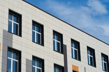 facade of a modern building on a bright Sunny day, siding and Windows, beautiful exterior of the new building