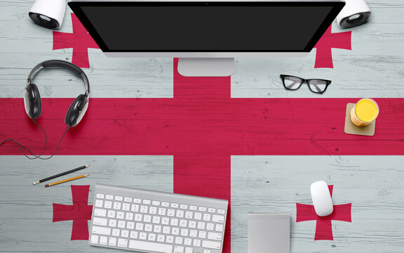 Georgia flag background with headphone,computer keyboard and mouse on national office desk table.Top view with copy space.Flat Lay. - Powered by Adobe