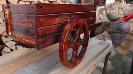 Hand painting wood. Detail of brush varnishing a small wooden wheel (restoration work)