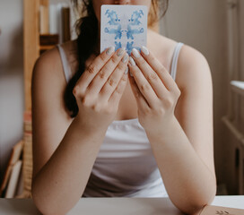 woman holding in her hands tarot cards