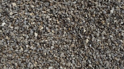 The texture of stone gravel gray. Stone rubble gray poured pile close-up.