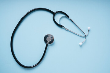 Stethoscope doctor clinic working desk over blue background.