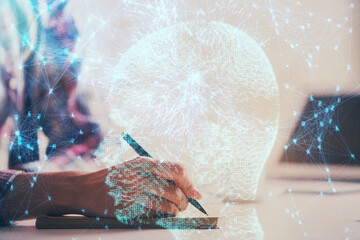 Double exposure of woman's writing hand on background with brain hud. Concept of learning.