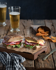 Homemade Panini stuffed with salami, cheese, tomatoes and onions. Served with a glass of beer and a...