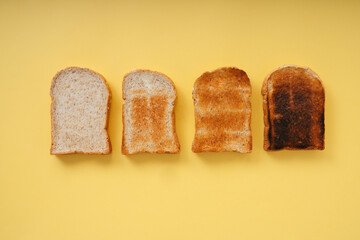Grill burnt home made organic sliced bread over yellow background.