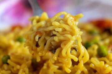 Fork holding spicy fried instant noodles,close up , selective focus.