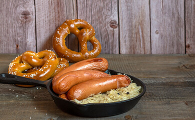 Traditional german sausages bratwurst with sauerkraut, and pretzels