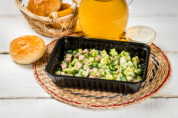 The basis for okroshka in a plastic, black container