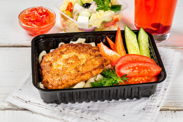 Cutlet with pasta, vegetables in a black container