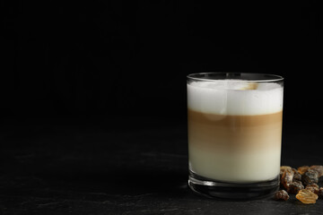 Delicious latte macchiato on table against black background, space for text