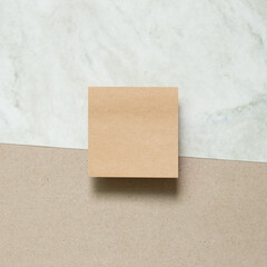 Brown kraft memo pad, empty paper on gray and brown background. top view, copy space