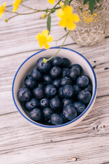 blueberries in a bowl on wooden table