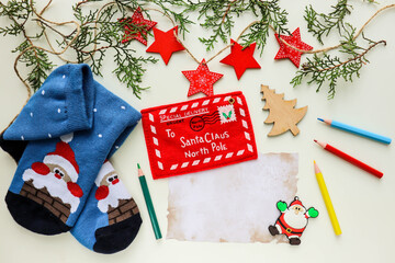 Fototapeta na wymiar christmas greeting card with santa claus. christmas sock with gifts on wood. Letter to Santa Claus. red envelope and red New Year's wooden stars.