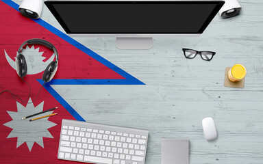 Nepal flag background with headphone,computer keyboard and mouse on national office desk table.Top view with copy space.Flat Lay.