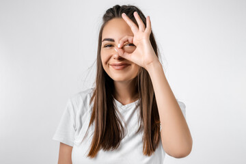Close up portrait of carefree modern girl with long chestnut hairs, looking at the camera through...