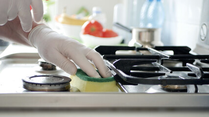 Busy Person in the Kitchen Wearing Gloves Cleans with Solution the Cooker Stove.