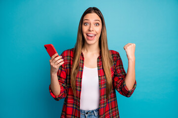 Portrait of her she nice attractive pretty lovely cheerful cheery long-haired girl wearing checked shirt using cell having fun isolated over bright vivid shine vibrant blue color background