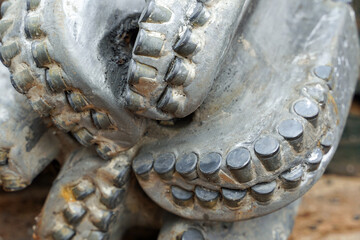 The drill bit, shot close-up with shallow depth of field. Industrial background. Macro shot of...